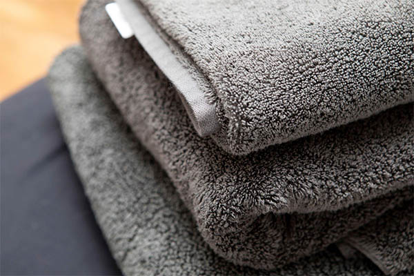 toalha de banho cinza com fio penteado em detalhes