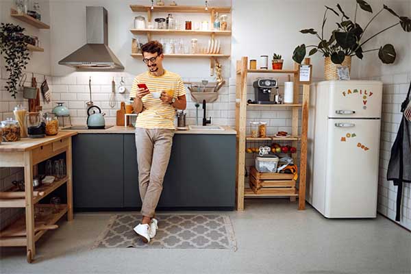 homem feliz na cozinha de casa