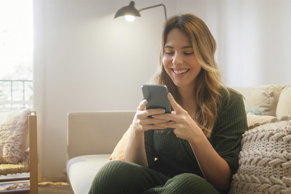 jovem mulher usando celular enquanto sorri